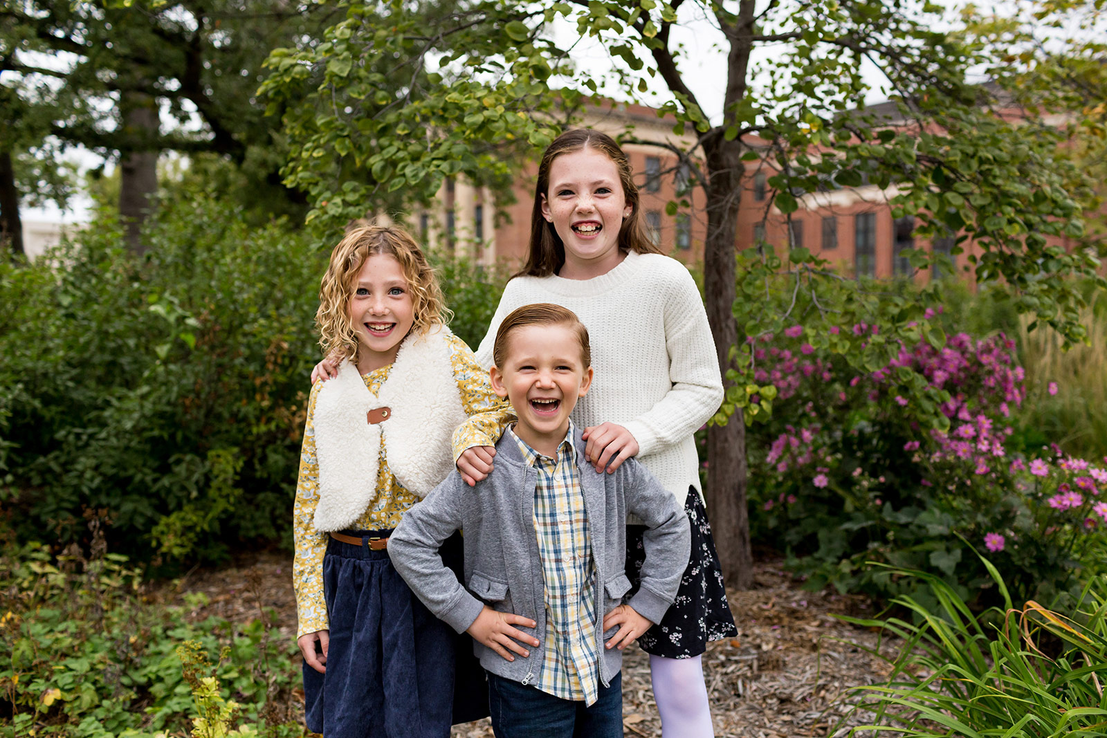 Nora, Ben and Harper laugh as they pose candidly for a portrait on campus..