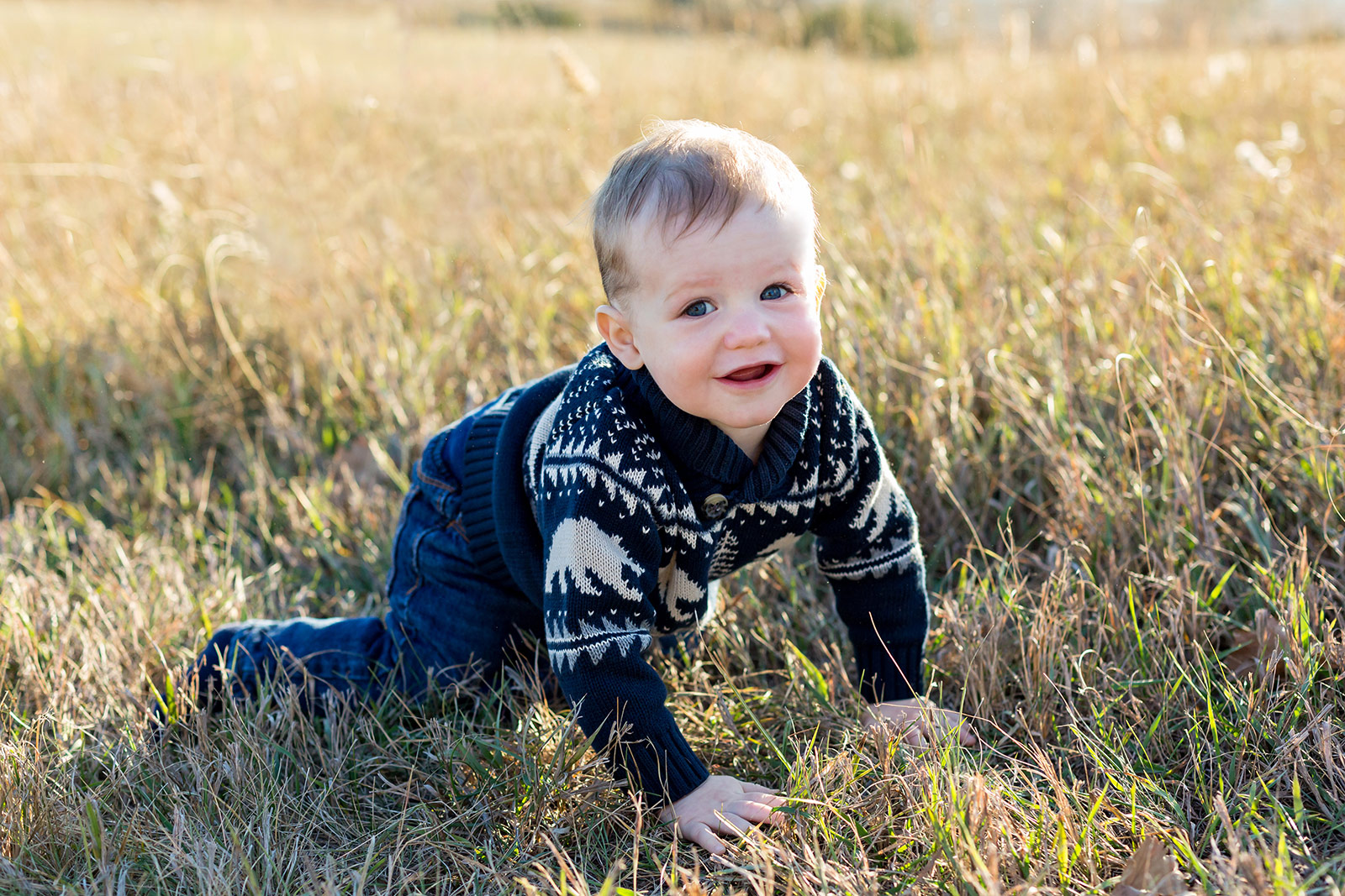 Beckham crawls through the tall grass with a sweet smile on his face.